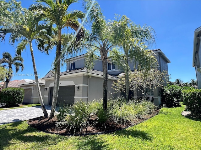 1192 Chinaberry Dr, Weston, FL 33327 - view of home's exterior with stucco siding, decorative driveway, a lawn, and a garage