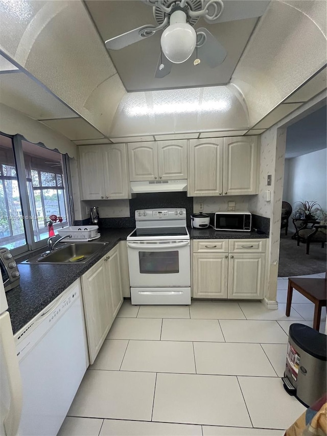 9330 Lime Bay Blvd Unit 315, Tamarac, FL 33321 - kitchen with white appliances, under cabinet range hood, a sink, dark countertops, and light tile patterned flooring