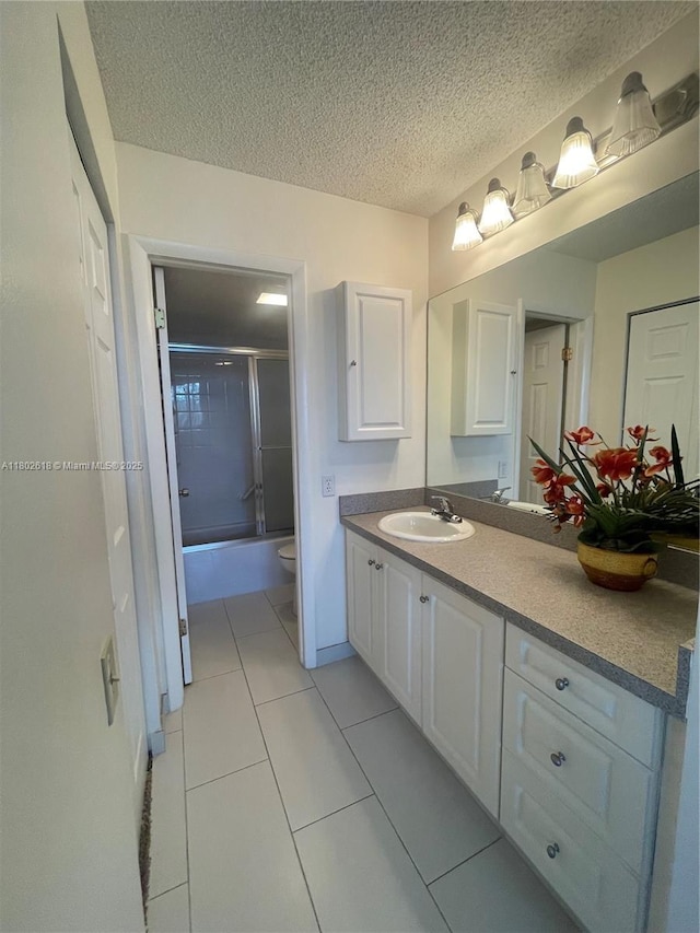 9330 Lime Bay Blvd Unit 315, Tamarac, FL 33321 - full bath with vanity, toilet, tile patterned floors, a textured ceiling, and enclosed tub / shower combo