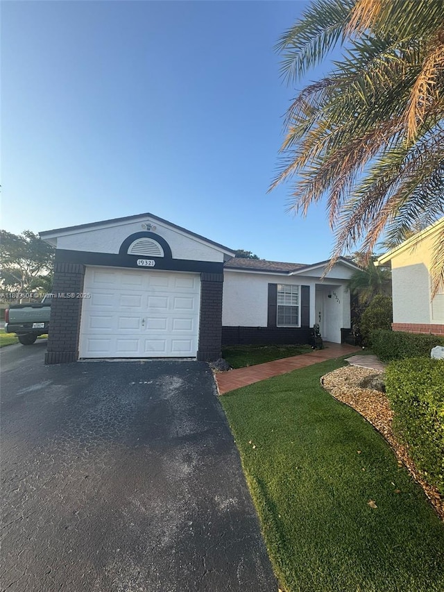 19321 NW 83rd Ave, Hialeah, FL 33015 - ranch-style house featuring asphalt driveway, brick siding, stucco siding, and a front yard