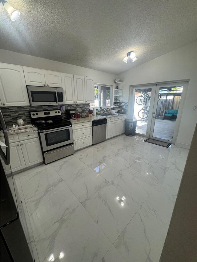 19321 NW 83rd Ave, Hialeah, FL 33015 - kitchen featuring stainless steel appliances, french doors, white cabinetry, a textured ceiling, and backsplash