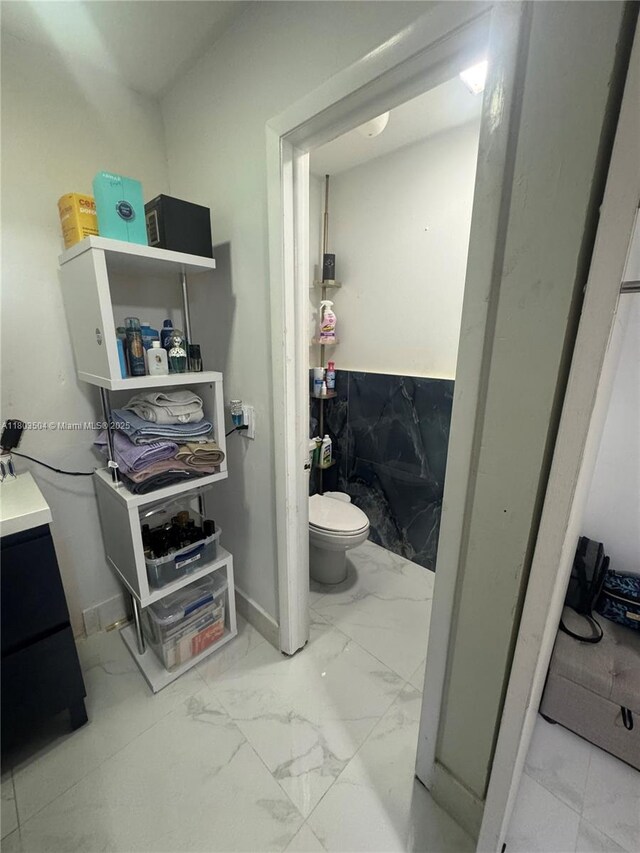 19321 NW 83rd Ave, Hialeah, FL 33015 - bathroom with marble look tile flooring and toilet