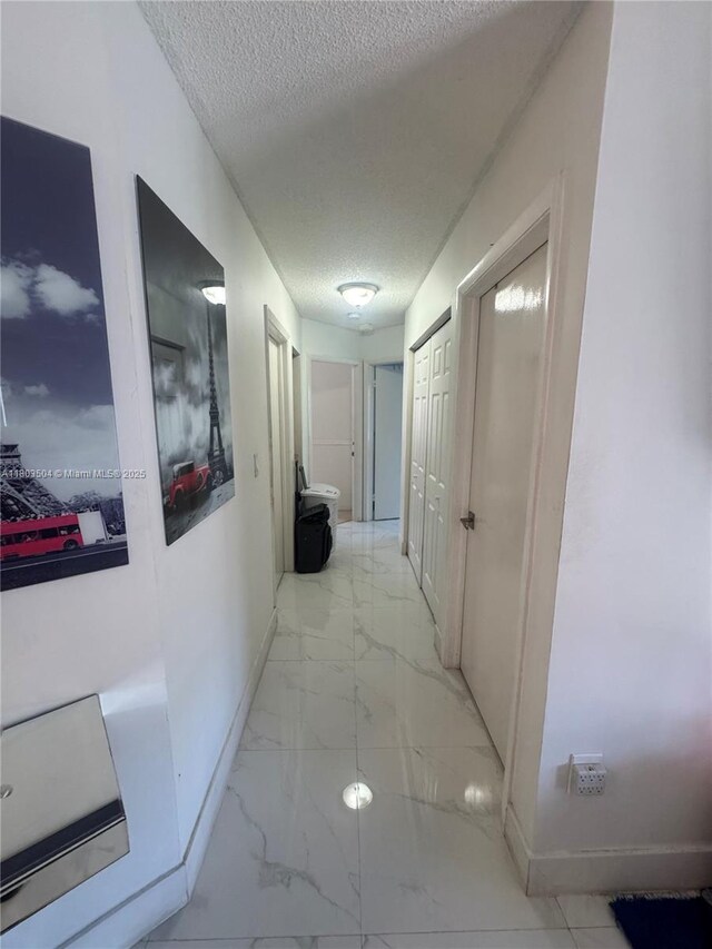 19321 NW 83rd Ave, Hialeah, FL 33015 - hall with light marble finish floors, a textured ceiling, and baseboards