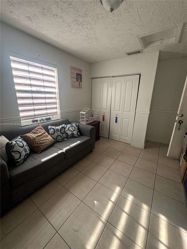 19321 NW 83rd Ave, Hialeah, FL 33015 - living area with attic access, light tile patterned floors, and a textured ceiling