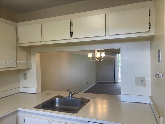 1124 NW 106th Ter Unit 202, Pembroke Pines, FL 33026 - kitchen with a sink, light countertops, a chandelier, and white cabinetry
