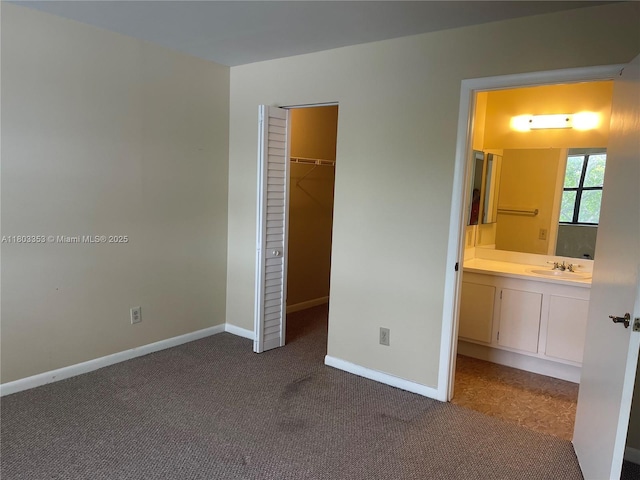 1124 NW 106th Ter Unit 202, Pembroke Pines, FL 33026 - unfurnished bedroom with a sink, a walk in closet, dark carpet, baseboards, and a closet