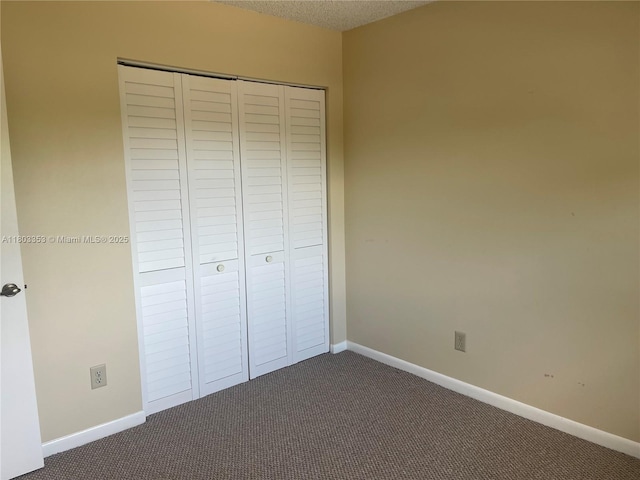 1124 NW 106th Ter Unit 202, Pembroke Pines, FL 33026 - unfurnished bedroom with dark carpet, a closet, baseboards, and a textured ceiling