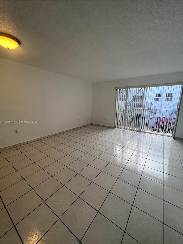 8170 NW 10th St Unit 2, Miami, FL 33126 - empty room with a textured ceiling and light tile patterned flooring