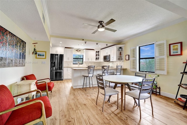 2679 S Ocean Blvd Unit 2B, Boca Raton, FL 33432 - dining area featuring a textured ceiling, a ceiling fan, ornamental molding, light wood-style floors, and baseboards