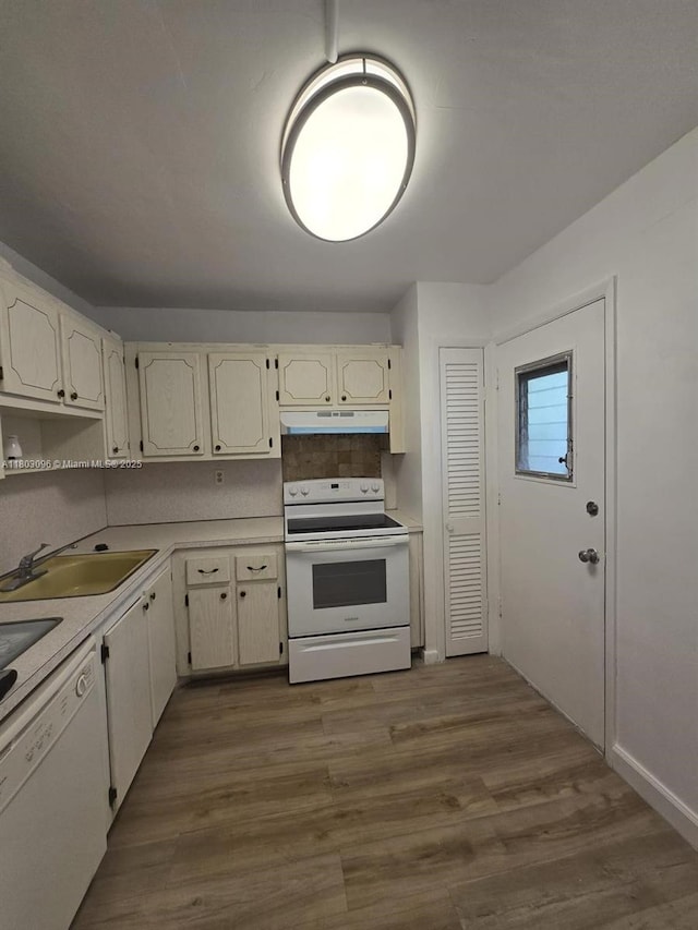 1201 NE 191st St Unit G211, Miami, FL 33179 - kitchen featuring white appliances, under cabinet range hood, a sink, light countertops, and dark wood finished floors