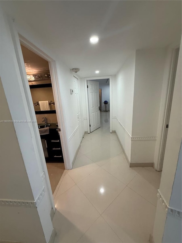1912 S Ocean Dr Unit 3D, Hallandale Beach, FL 33009 - hallway featuring baseboards, a sink, light tile patterned flooring, and recessed lighting