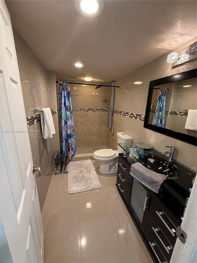1912 S Ocean Dr Unit 3D, Hallandale Beach, FL 33009 - full bath featuring a stall shower, toilet, vanity, tile patterned flooring, and tile walls