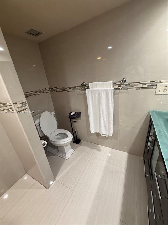 1912 S Ocean Dr Unit 3D, Hallandale Beach, FL 33009 - bathroom featuring toilet, vanity, tile walls, and tile patterned flooring