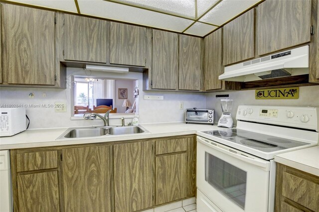 424 SE 10th St Unit 405, Dania Beach, FL 33004 - kitchen featuring white appliances, under cabinet range hood, a sink, and light countertops