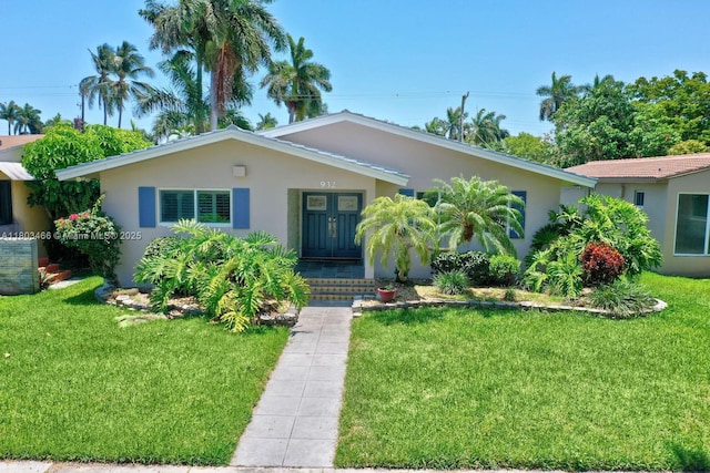932 Polk St, Hollywood, FL 33019 - single story home with a front yard, stucco siding, and french doors
