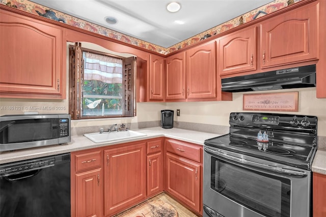 kitchen featuring appliances with stainless steel finishes, under cabinet range hood, a sink, light countertops, and brown cabinets