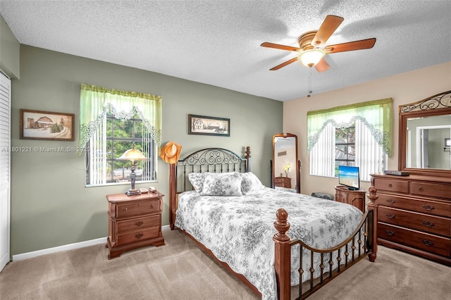 bedroom with carpet, a textured ceiling, ceiling fan, and baseboards