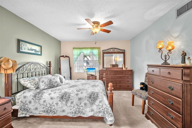 carpeted bedroom with a textured ceiling and a ceiling fan