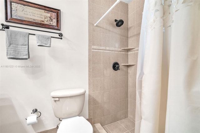 bathroom with tiled shower and toilet