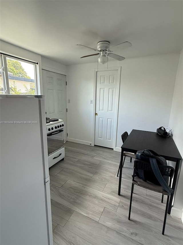 3195 W 10th Ave, Hialeah, FL 33012 - kitchen with white appliances, a ceiling fan, baseboards, and a desk