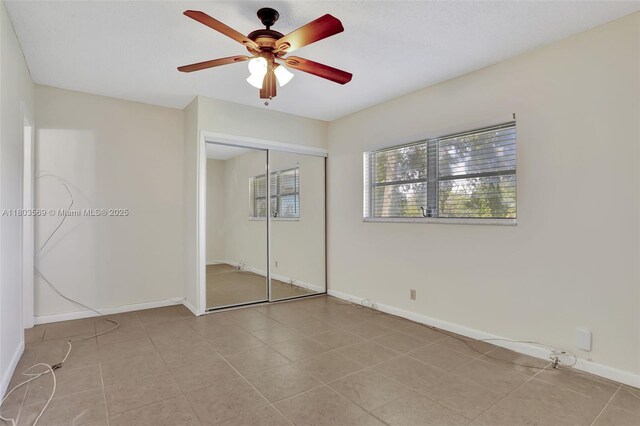 551 NW 80th Ter Unit 203, Margate, FL 33063 - unfurnished bedroom featuring a closet, baseboards, light tile patterned floors, and ceiling fan
