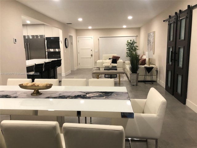 9224 Byron Ave, Surfside, FL 33154 - dining area with recessed lighting, baseboards, a barn door, and finished concrete floors