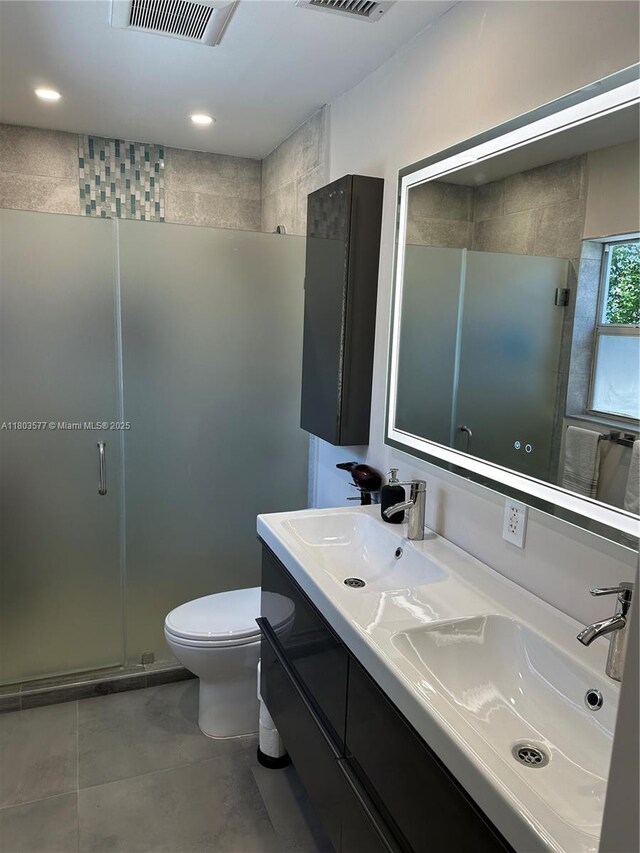 9224 Byron Ave, Surfside, FL 33154 - full bath featuring a stall shower, toilet, double vanity, tile patterned flooring, and recessed lighting