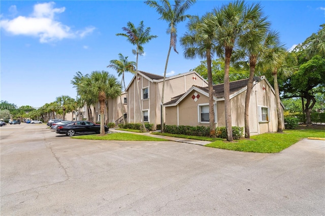 9641 Riverside Dr Unit F6, Coral Springs, FL 33071 - view of front of house featuring uncovered parking, stucco siding, and a front lawn