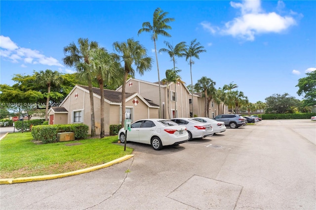 9641 Riverside Dr Unit F6, Coral Springs, FL 33071 - view of front facade with uncovered parking, a front yard, and stucco siding