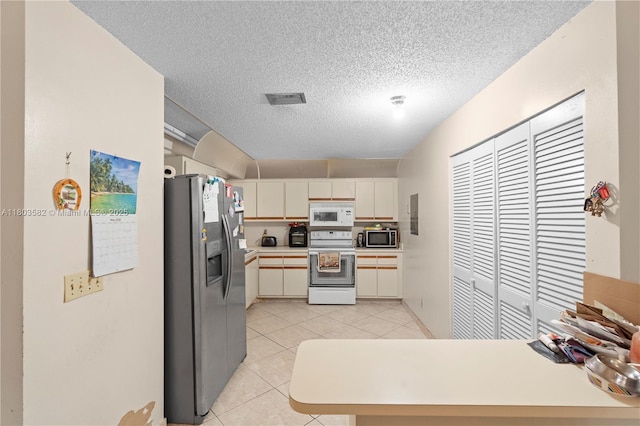 9641 Riverside Dr Unit F6, Coral Springs, FL 33071 - kitchen featuring stainless steel appliances, a peninsula, a textured ceiling, light countertops, and light tile patterned floors