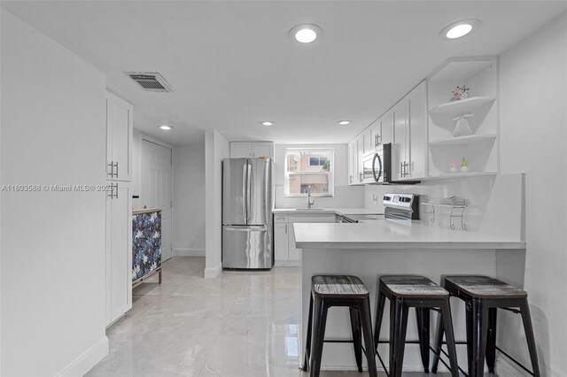 5530 W 26th Ct Unit 209, Hialeah, FL 33016 - kitchen featuring stainless steel appliances, open shelves, baseboards, recessed lighting, and white cabinets