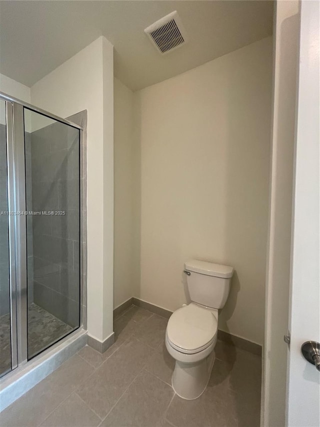full bath with toilet, a stall shower, tile patterned flooring, and baseboards