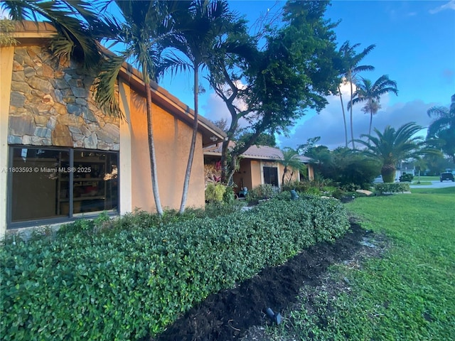 2180 SW 115th Ter, Davie, FL 33325 - view of side of home with a lawn, stucco siding, and stone siding