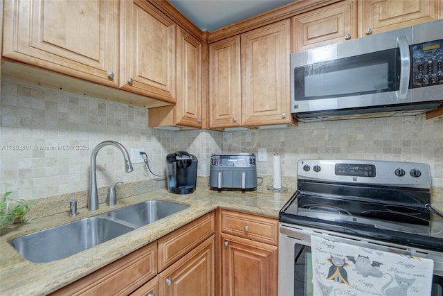 1625 SE 10th Ave Unit 607, Fort Lauderdale, FL 33316 - kitchen with stainless steel appliances, a sink, decorative backsplash, light stone counters, and brown cabinetry