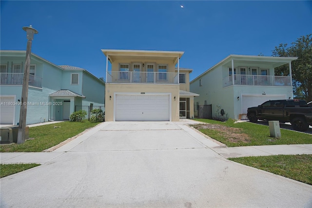 view of front of home featuring a balcony, an attached garage, driveway, and a front lawn