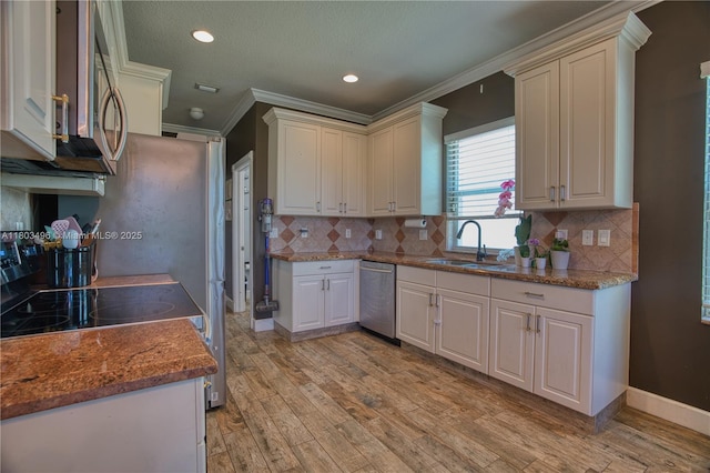 kitchen featuring a sink, crown molding, stainless steel appliances, light wood-style floors, and tasteful backsplash