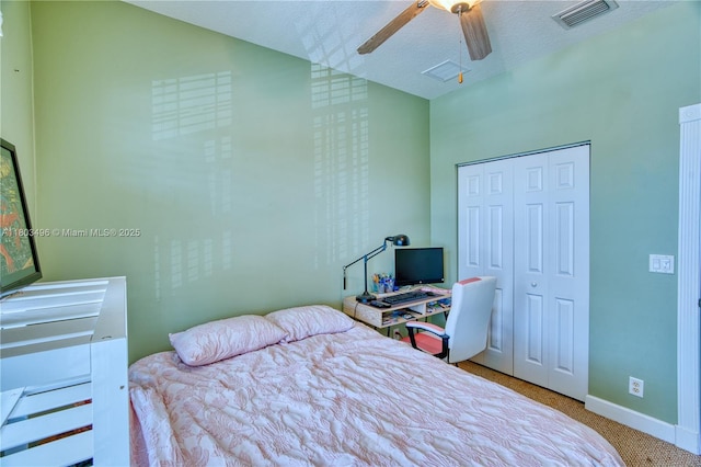carpeted bedroom with a closet, baseboards, and ceiling fan