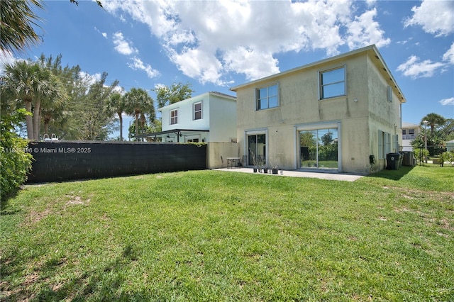 rear view of house featuring stucco siding and a patio area