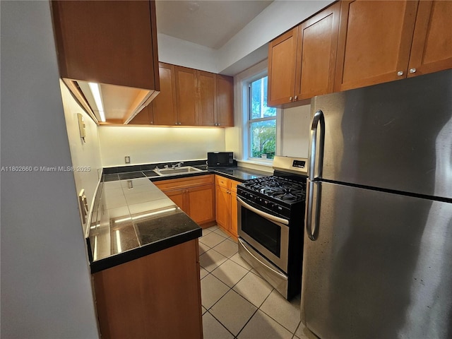 900 16th St Unit 207, Miami Beach, FL 33139 - kitchen featuring appliances with stainless steel finishes, light tile patterned floors, brown cabinets, a sink, and tile counters