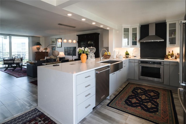 401 SE 3rd St Unit 403, Dania Beach, FL 33004 - kitchen with stainless steel appliances, wall chimney exhaust hood, a sink, a peninsula, and recessed lighting