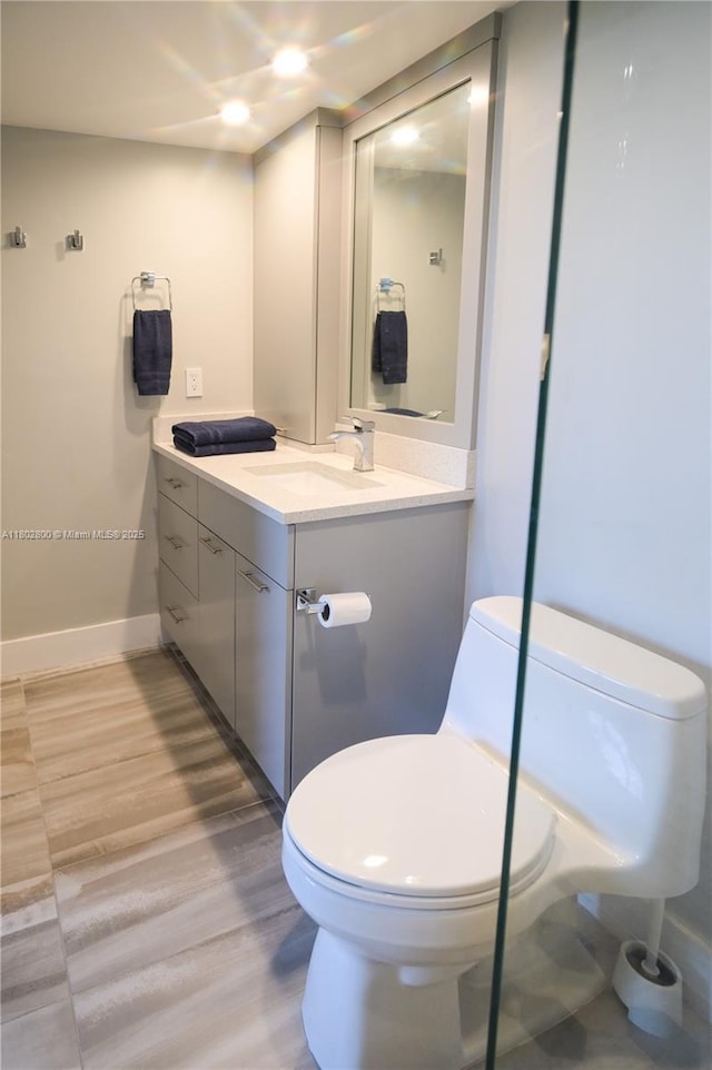 401 SE 3rd St Unit 403, Dania Beach, FL 33004 - bathroom with toilet, vanity, baseboards, and wood finished floors