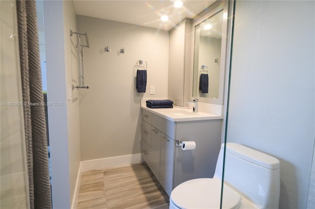401 SE 3rd St Unit 403, Dania Beach, FL 33004 - bathroom featuring toilet, wood finished floors, baseboards, and vanity