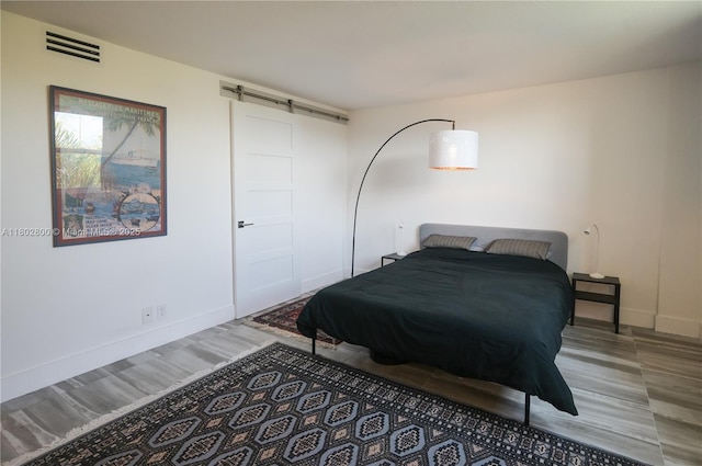401 SE 3rd St Unit 403, Dania Beach, FL 33004 - bedroom featuring wood finished floors, baseboards, and a barn door