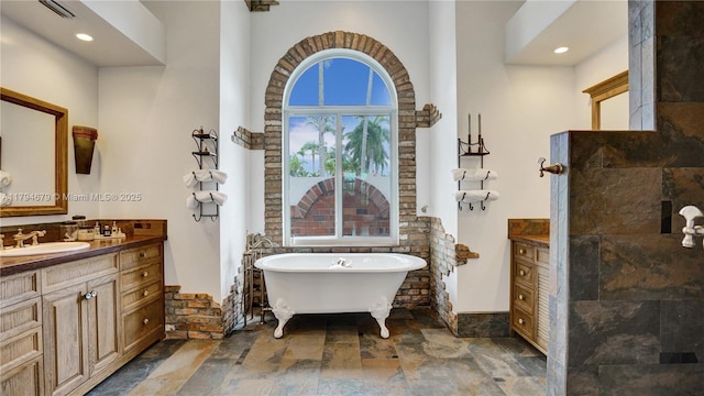2495 Eagle Watch Ln, Weston, FL 33327 - bathroom featuring stone tile flooring, vanity, a soaking tub, and recessed lighting