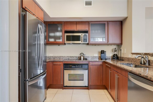 2080 S Ocean Dr Unit Ph4, Hallandale Beach, FL 33009 - kitchen featuring appliances with stainless steel finishes, a sink, light stone counters, and brown cabinets