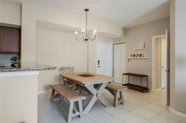 2080 S Ocean Dr Unit Ph4, Hallandale Beach, FL 33009 - dining area featuring light tile patterned flooring, a chandelier, and baseboards