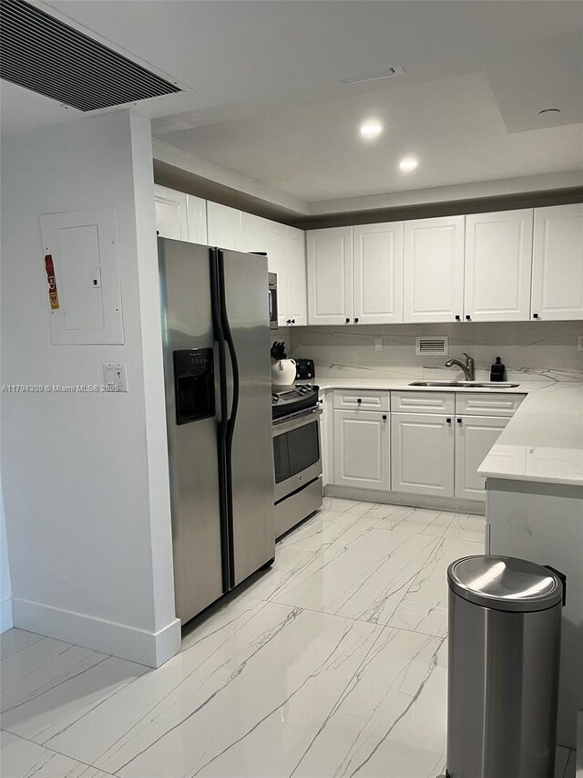 2301 Collins Ave Unit 326, Miami Beach, FL 33139 - kitchen with appliances with stainless steel finishes, light countertops, electric panel, white cabinetry, and recessed lighting