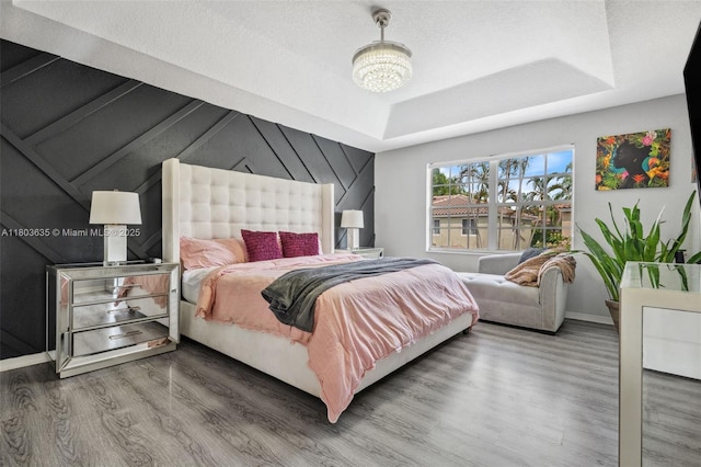 2238 NW 139th Ave, Sunrise, FL 33323 - bedroom with wood finished floors, baseboards, a raised ceiling, and a chandelier
