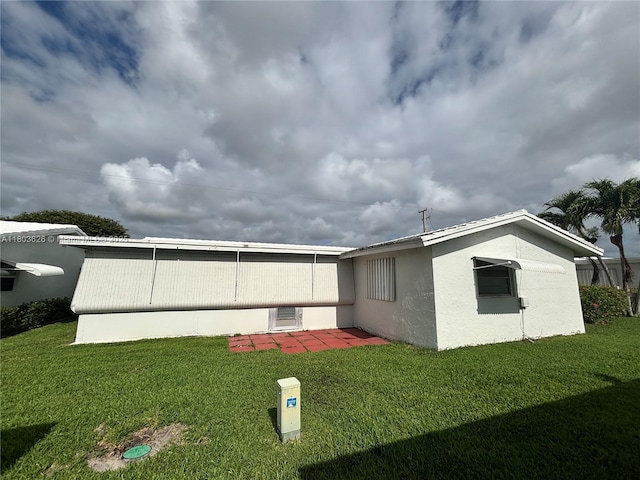 back of house featuring a yard and stucco siding