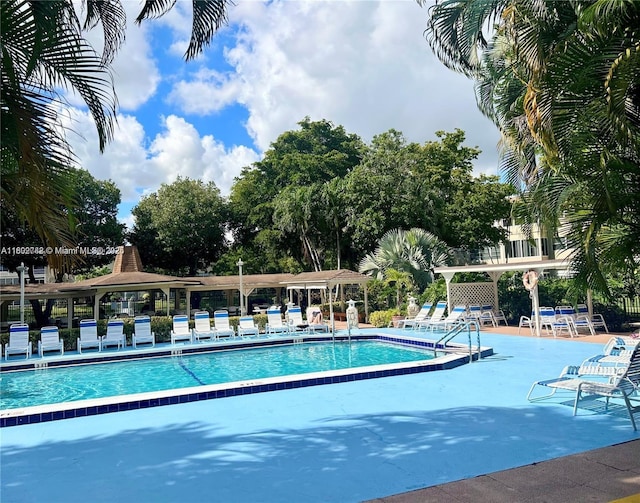 community pool with a gazebo and a patio area